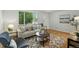 Bright living room with hardwood floors, neutral-toned sofa, stylish rug, and a large window showcasing the outdoor view at 1376 Ivanhoe St, Denver, CO 80220