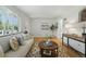 Cozy living room with hardwood floors, a comfortable sofa, stylish rug, and a large window at 1376 Ivanhoe St, Denver, CO 80220