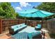 Outdoor patio with comfortable seating, a shade umbrella, and a patterned rug creating a cozy backyard retreat at 1376 Ivanhoe St, Denver, CO 80220