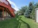 Beautifully maintained backyard featuring a red deck and mature trees that provide ample shade at 207 Short Pl, Louisville, CO 80027