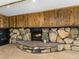 Basement fireplace with stone surround, wood paneling, carpet floors and recessed lighting at 207 Short Pl, Louisville, CO 80027