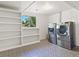Bright laundry room features modern washer and dryer, window with view, and built-in shelving at 207 Short Pl, Louisville, CO 80027
