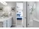 Bright en-suite bathroom with dual vanity sinks, a glass enclosed shower, and a view of the bedroom at 1588 Blackwood Ct, Erie, CO 80516