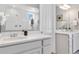 Bright bathroom featuring double vanities, a large mirror reflecting the walk-in shower, and neutral paint at 1588 Blackwood Ct, Erie, CO 80516