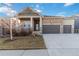 Attractive single-Gathering home with stone accents, a covered porch, and a three-car garage against a blue sky at 1588 Blackwood Ct, Erie, CO 80516