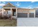 Charming home with a stone facade, three car garage, and covered porch at 1588 Blackwood Ct, Erie, CO 80516