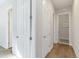 Neutral hallway featuring white walls, hardwood floors, and multiple white doors leading to other rooms at 1588 Blackwood Ct, Erie, CO 80516