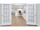 Bright hallway with light wood floors, white trim, and French doors for a bright and welcoming space at 1588 Blackwood Ct, Erie, CO 80516