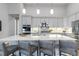 Modern kitchen with stainless steel appliances, a spacious island with seating, and stylish pendant lighting at 1588 Blackwood Ct, Erie, CO 80516