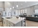 Bright open kitchen with stainless appliances, large island with seating, and modern pendant lighting at 1588 Blackwood Ct, Erie, CO 80516