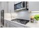 Close-up of a modern kitchen with a gas cooktop, quartz countertops, and stainless steel appliances at 1588 Blackwood Ct, Erie, CO 80516