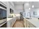 A modern kitchen featuring white cabinets, stainless steel appliances, and a spacious island with a sink at 1588 Blackwood Ct, Erie, CO 80516