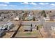 Aerial shot of house with spacious backyard, neighborhood, mature trees, and blue skies at 1603 S Flanders Way, Aurora, CO 80017