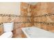 Cozy bathroom with a bathtub, shower, and tile surround at 1603 S Flanders Way, Aurora, CO 80017