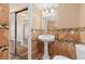 Bathroom featuring tiled walls, pedestal sink, and a vanity mirror at 1603 S Flanders Way, Aurora, CO 80017