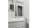 Clean white bathroom features a white sink and a large mirror reflecting a gray door at 6705 S Field St # 803, Littleton, CO 80128