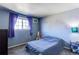 Bedroom with blue walls, carpet, window with purple curtains, and furniture at 2863 S Biscay Ct, Aurora, CO 80013