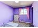 Bedroom with purple walls, carpet, and window with pink curtains at 2863 S Biscay Ct, Aurora, CO 80013