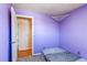 Bedroom with purple walls, carpet, closet, and doorway to another room at 2863 S Biscay Ct, Aurora, CO 80013