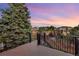 Inviting wood deck with black metal railings offer outdoor living with neighborhood views at sunset at 17166 Yellow Rose Way, Parker, CO 80134