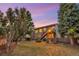 Exterior twilight view shows the upper deck, access stairs, lower patio and a grassy backyard at 17166 Yellow Rose Way, Parker, CO 80134