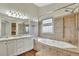 Luxurious bathroom with a soaking tub, tiled surround, glass shower, and double vanity at 17166 Yellow Rose Way, Parker, CO 80134