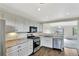 The charming kitchen features white cabinets, modern appliances, and an opening to the spacious living room at 17166 Yellow Rose Way, Parker, CO 80134