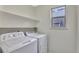Functional laundry area features a washer, dryer, and shelving providing convenient space at 17166 Yellow Rose Way, Parker, CO 80134