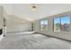 Bright living room with a vaulted ceiling, neutral carpet, and large windows providing plenty of natural light at 17166 Yellow Rose Way, Parker, CO 80134