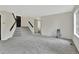 Open-concept living room featuring carpet, stairs to the upper level, and access to the bathroom at 17166 Yellow Rose Way, Parker, CO 80134
