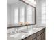 Bathroom features a double sink vanity, a large mirror, and modern fixtures at 6485 E Cedar Ave, Denver, CO 80224