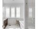 Modern bathroom featuring a soaking tub, tiled walls, and a glass-enclosed shower at 6485 E Cedar Ave, Denver, CO 80224