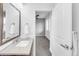 Bathroom featuring white sink, dark cabinets, and an open door to a bedroom at 6485 E Cedar Ave, Denver, CO 80224