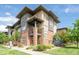 Multi-story home with brick and siding, a small balcony, and beautiful landscaping at 6485 E Cedar Ave, Denver, CO 80224