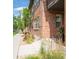 Brick townhome showcasing landscaped walkway with vibrant flowers and greenery near the front door at 6485 E Cedar Ave, Denver, CO 80224