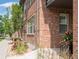 Brick building with manicured landscaping including trees, grass, and flowers lining the sidewalk at 6485 E Cedar Ave, Denver, CO 80224