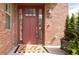 Charming front door entrance with sidelights and a welcome mat on the front porch at 6485 E Cedar Ave, Denver, CO 80224