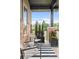 Inviting front porch with stylish furniture, planters, and a striped rug at 6485 E Cedar Ave, Denver, CO 80224