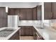 Modern kitchen with stainless steel appliances, dark wood cabinets, light countertops and backsplash at 6485 E Cedar Ave, Denver, CO 80224