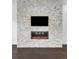 Modern living area featuring a stone accent wall with a fireplace and mounted TV at 6485 E Cedar Ave, Denver, CO 80224
