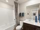 Bathroom featuring a tub with shower, vanity with dark wood cabinets, a white toilet, and blue decorative elements at 20802 E 66Th Ave, Aurora, CO 80019