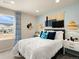 Bedroom featuring white bedding, woven pendant lights, accent wall hanging, desk, chair, and a window with neighborhood view at 20802 E 66Th Ave, Aurora, CO 80019