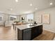 Kitchen island with granite counters and breakfast bar open to living room area at 20802 E 66Th Ave, Aurora, CO 80019