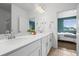 Bathroom featuring double vanity, quartz countertops, white cabinets, and view to the bedroom at 650 Bishop Pine Way, Castle Rock, CO 80104