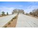 Home exterior showing a long driveway, attached garages, stone accents, landscaping, and covered porch at 650 Bishop Pine Way, Castle Rock, CO 80104