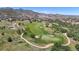 Scenic aerial view of a lush golf course surrounded by natural landscapes and a picturesque mountain backdrop at 10950 Elk Horn Run, Littleton, CO 80125
