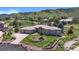 Aerial view of the house featuring a three-car garage, beautifully landscaped lawn, and mountain views at 10950 Elk Horn Run, Littleton, CO 80125