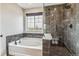 Modern bathroom featuring a soaking tub, a glass enclosed shower and stylish tile work at 6105 N Hanover St, Denver, CO 80238