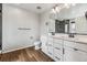 Modern bathroom with double sinks, white cabinets, and updated fixtures at 6105 N Hanover St, Denver, CO 80238