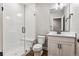 Bright bathroom with a glass-door shower, white vanity, and tiled floor at 6105 N Hanover St, Denver, CO 80238